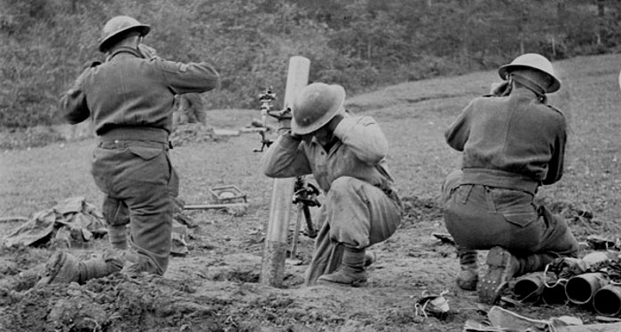 Unidentified infantrymen of the 3rd Canadian Infantry Brigade firing a mortar near the Sangro River, Italy, 1 December 1943.