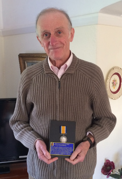 John Butler is shown holding his father's British War Medal.